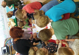 Dzieci z grupy II z nauczycielką wykonują pracę plastyczną 