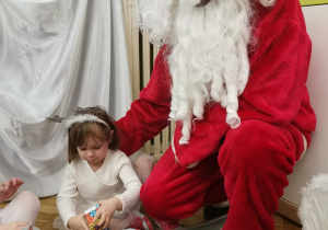 Mikołaj rozdaje prezenty dziewczynce