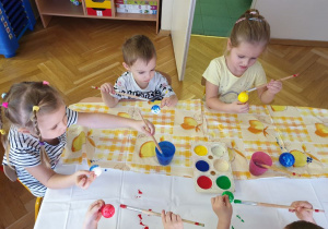 Zdjęcie z góry na dzieci malujące farbami styropianowe bombki
