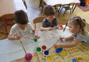 Zdjęcie z góry na dzieci malujące farbami styropianowe bombki 