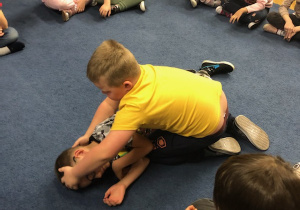 Chłopiec uklada dziecko w pozycji bocznej ustalonej