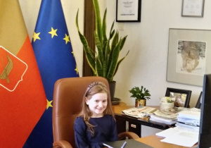 Dziewczynka siedzi za biurkiem pani prezydent
