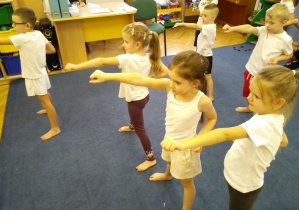 Dzieci ćwiczą w pozycji stojacej