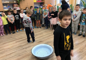 Dzieci stoją przy misce z woda