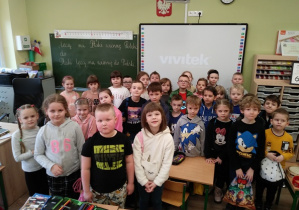 Dzieci stoją przy tablicy interaktywnej w jednej z klas w szkole