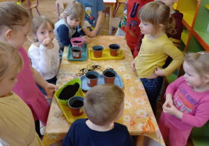 Dzieci chwala się swoją pracą z sadzenia kwiatow