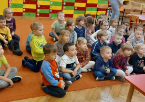 Dzieci siedzą na dywanie I oglądają doświadczenia