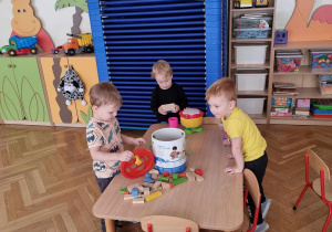Chłopcy bawią się przy stole klockami