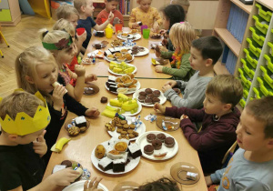 Dzieci jedzą poczęstunek s sali