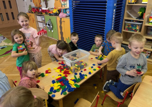 Dzieci budują z klocków przy stolikach