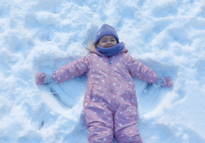 dziewczynka robi aniołka na śniegu