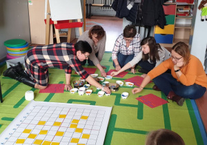 Panie nauczycielki grają w grę na dywanie