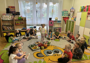 Dzieci na dywanie próbują różnych warzyw