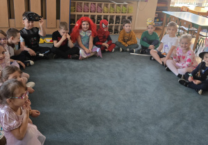 Dzieci siedzą na dywanie