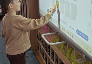 Chłopiec przy tablicy rozwiązuje zadanie