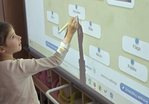 Dziewczynka stoi przy tablicy