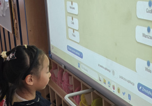 Dziewczynka stoi przy tablicy