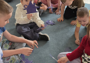 Dzieci siedzą na dywanie