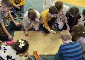 Dzieci wyklejają bibuła misia