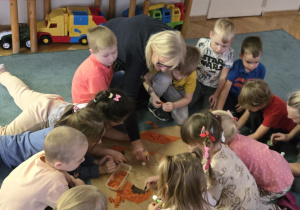 Dzieci wyklejają misia