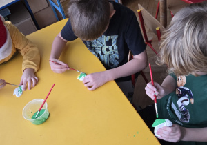 Chłopcy malują figurki z gipsu