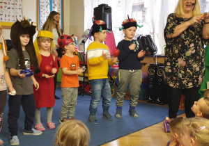 Dzieci w zabawnych czapkach grają na instrumentach do muzyki karnawałowej