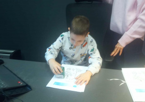 Dziecko siedzi w gabinecie przy biurku