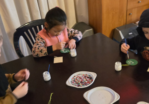 Dzieci przy stole dekorują bomkbę