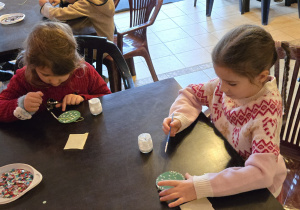 Dzieci przy stole dekorują bomkbę