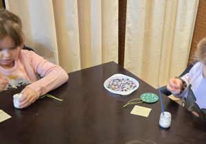 Dzieci przy stole dekorują bomkbę