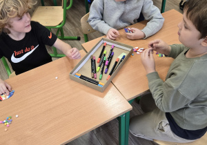 Dzieci przy stole dekorują skrzaty