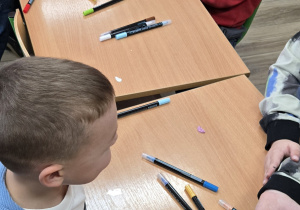 Dzieci pracują 0rzy stolikach