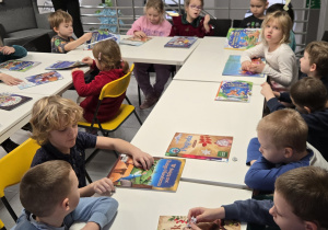 Dzieci siedzą przy świątecznych książkach