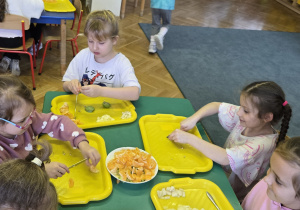 Dzieci robią sałatkę owocową