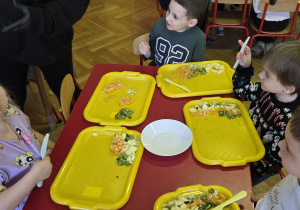 Dzieci robią sałatkę owocową