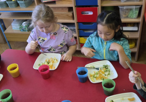 Dzieci jedzą sałatkę owocową