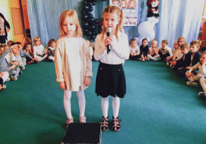 Dwie dziewczynki recytują wiersz.