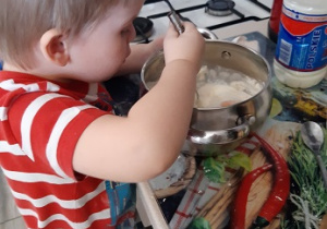 Chłopiec pomaga mieszając ciasto
