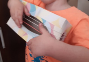 chłopiec gra na zrobionej przez siebie gitarze