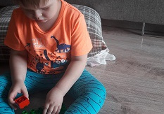 chłopiec bawi się klockami na podłodze w domu