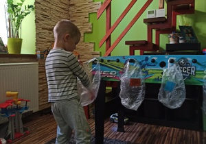 chłopiec segreguje śmieci do odpowiednich torebek