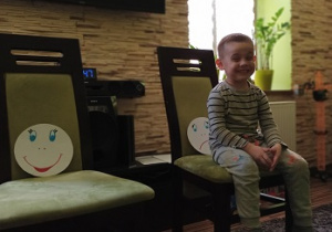 chłopiec siedzi na krześle podczas zabawy tak/ nie