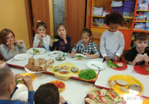 Spożywanie przez dzieci samodzielnie wykonnaych kanapek. 