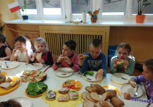Spożywanie przez dzieci samodzielnie wykonnaych kanapek. 