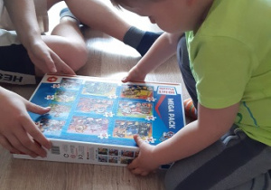 chłopiec trzyma pudełko z puzzlami