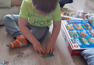 chłopiec układa puzzle