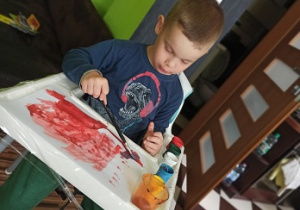 chłopiec maluje farbami