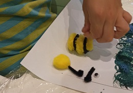 chłopiec przykleja pszczółkę