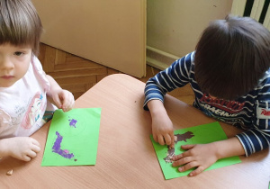 dzieci rozcierają plastelinę na ślimaku