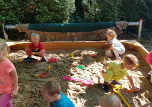 Dzieci bawią się foremkami do piasku.